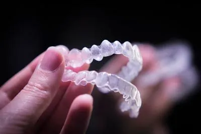 person holding their clear aligners